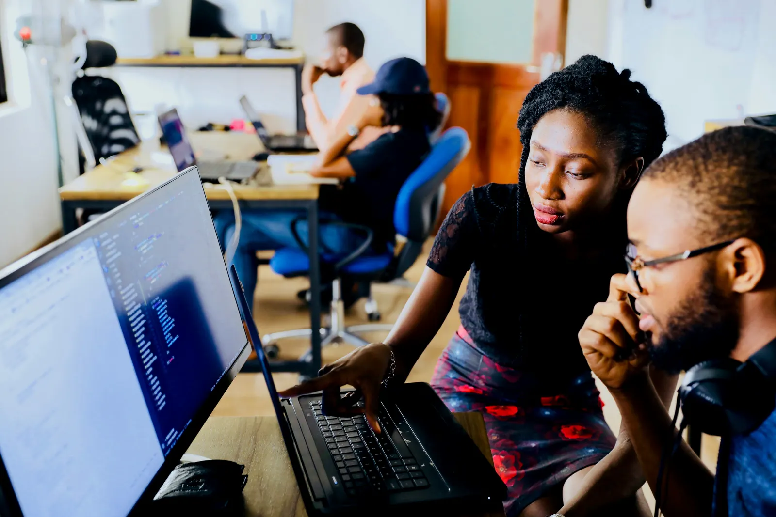 Two colleagues reviewing software code together at a monitor