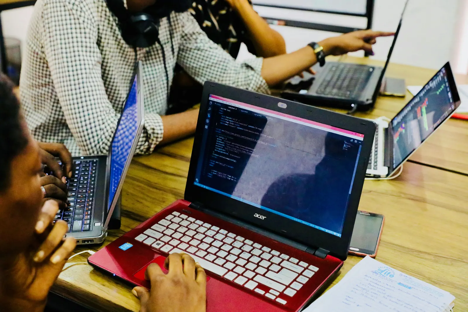 Web designers working on laptops with code on screen
